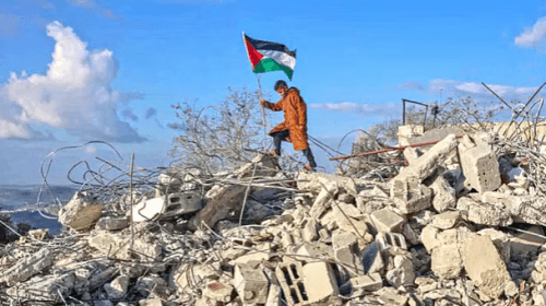 পশ্চিম তীরের ফিলিস্তিনি গ্রাম বাজরিয়ায় ইসরায়েলি সেনাবাহিনীর ধ্বংস করে দেওয়া একটি বাড়ির ধ্বংসস্তূপের ওপর পতাকা হাতে এক কিশোরএএফপি